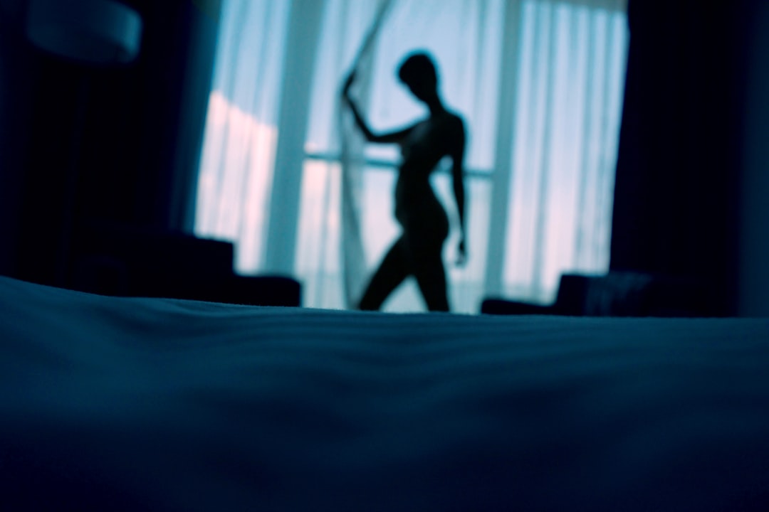 sillouehtte-photo-of-woman-standing-beside-window-curtains-72gW8GWP_vE