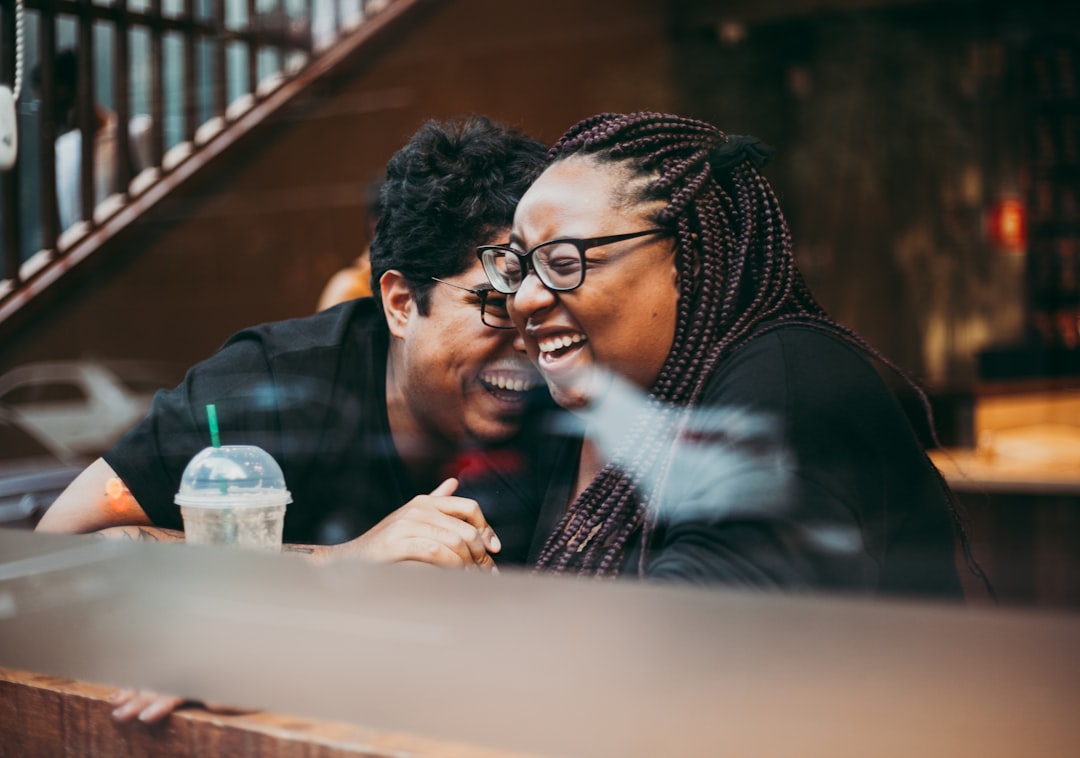 man-and-woman-sitting-and-laughing-RtSa0uuWrqI