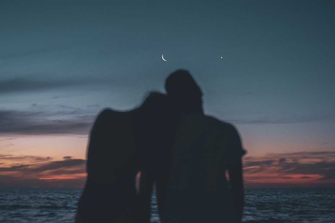 silhouette-of-man-and-woman-standing-on-beach-during-sunset-6U97YfljDK4