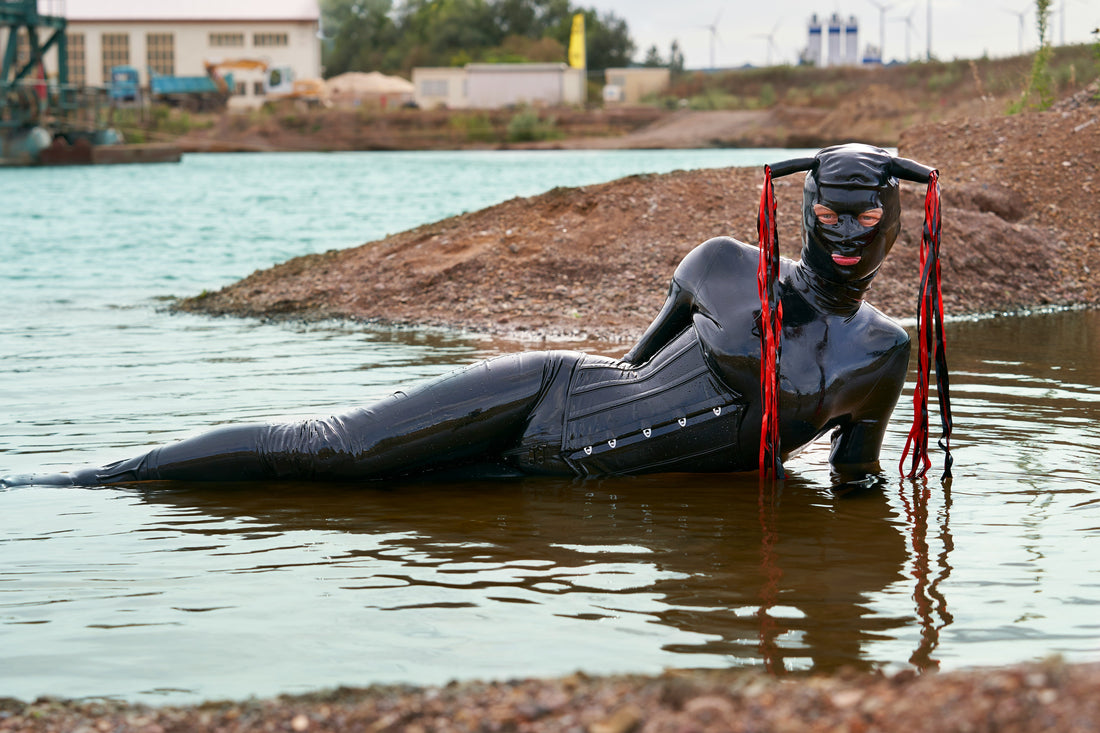 a-man-in-a-wet-suit-floating-in-a-body-of-water-FLI9KX0AFEM