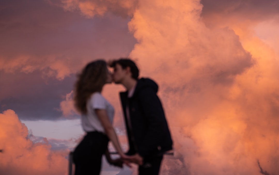 man-and-woman-kissing-under-cloudy-sky-during-daytime-FKjkEEBn5II