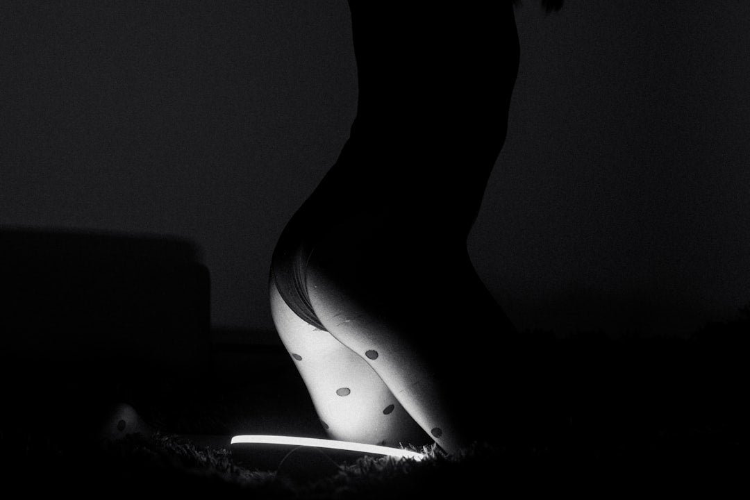 a-black-and-white-photo-of-a-womans-legs-in-the-dark-t67hILe-uQg