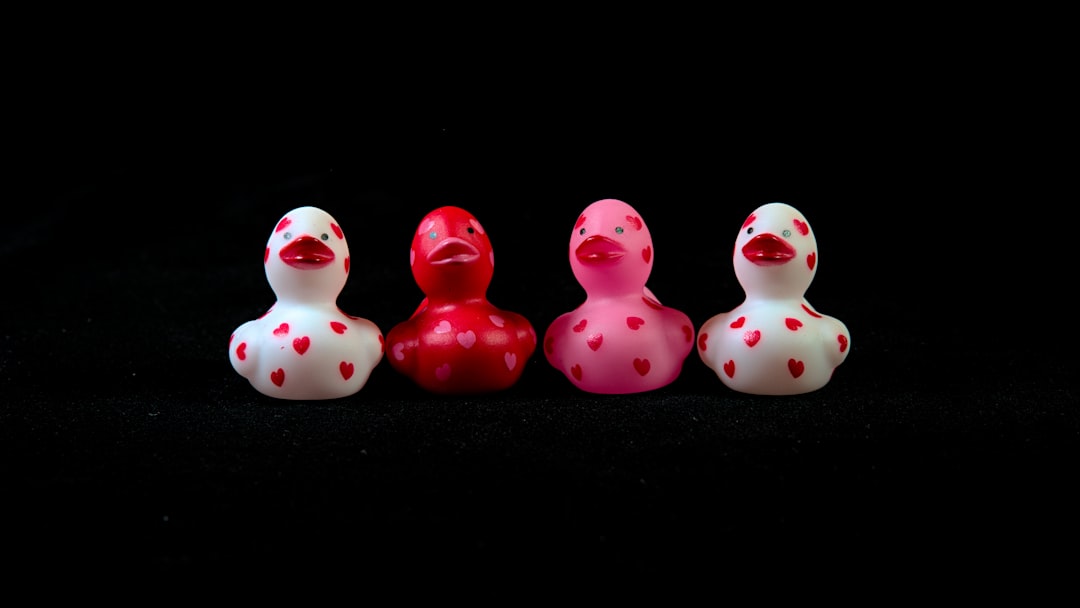 a-group-of-three-rubber-ducks-sitting-next-to-each-other-SCvWaZE5cHY