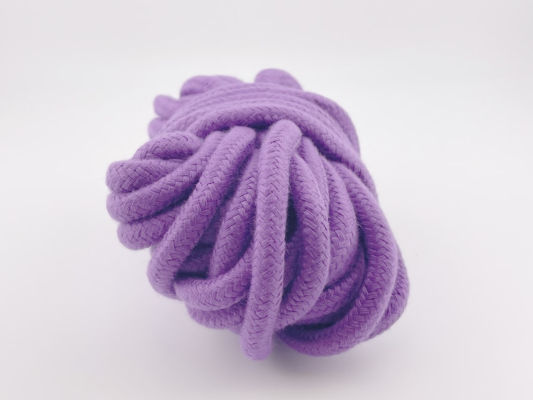 a-purple-ball-of-rope-on-a-white-background-4dXgkbxvHwE