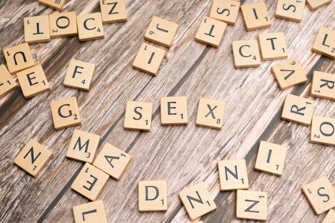 scrabble-tiles-spelling-out-the-word-sex-on-a-wooden-table-NBB7kyLZTys