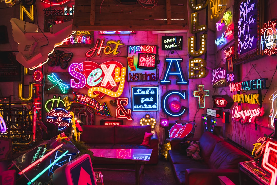 a-room-filled-with-neon-signs-and-furniture-L4xvY7Y7OdM