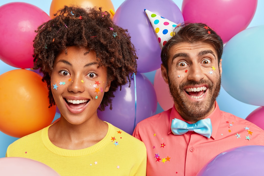 a-man-and-a-woman-standing-in-front-of-balloons-afORyNDnfhs