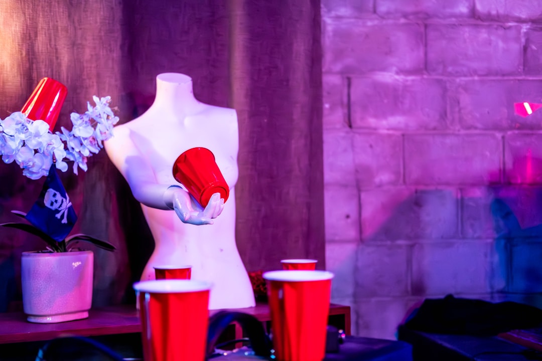 a-mannequin-with-a-red-hat-and-red-cups-e3dj3DZ2s0M