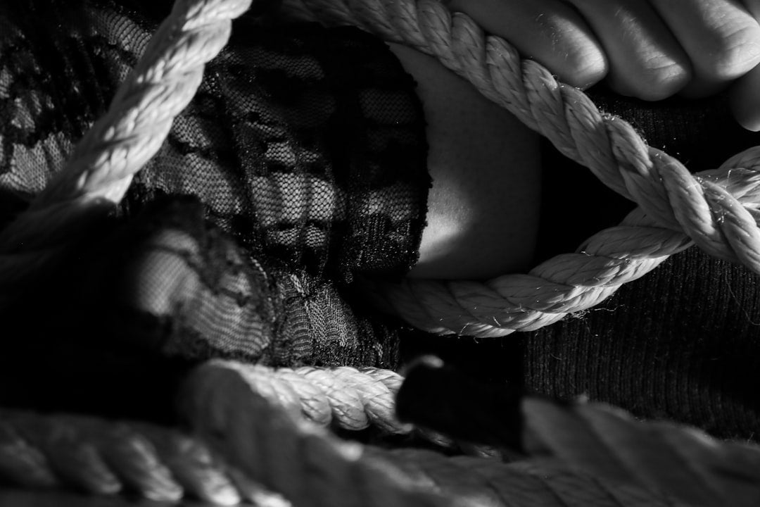 a-close-up-of-a-womans-torso-wrapped-in-thick-rope-wjm-qqqBwH0